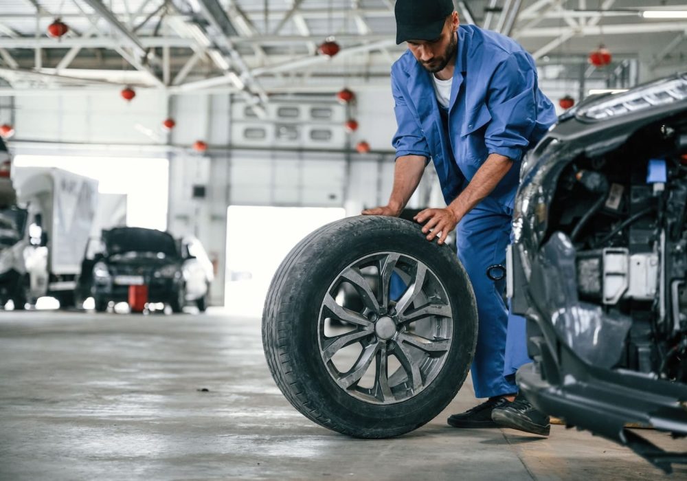 new-tire-moving-it-auto-mechanic-working-in-gara-2023-11-27-05-36-50-utc